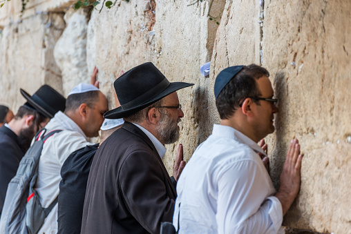 Othodox jewish men wailing at Western Wall, Wailing Wall, an ancient limestone wall in the Old City of Jerusalem, part of the expansion of the Second Jewish Temple, Israel