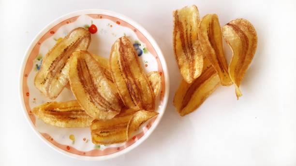 istock Fried sliced banana chips on white background. 1289501135