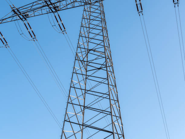 istock Electricity pylon in the middle from below under a blue sky 1289503638