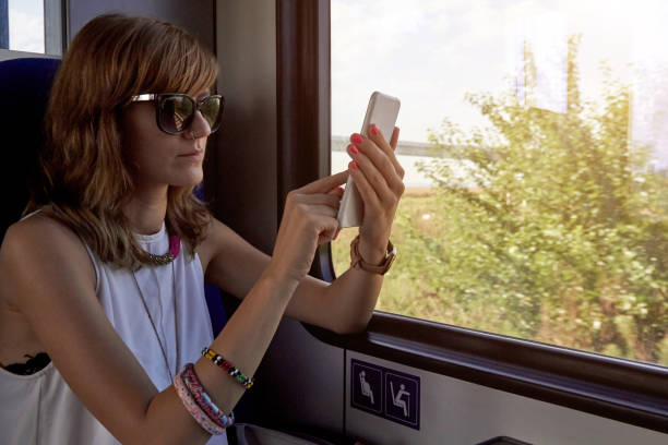 istock Woman riding in a train / metro wagon and using cellphone. 1289512676