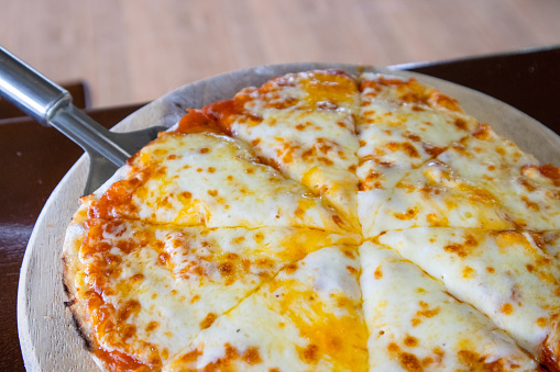 Homemade Pizza made from dough topped with spices like ham, sausage , vegetables and cheese