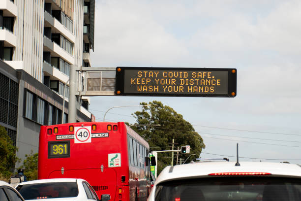 istock Changeable electronic dynamic road sign reads -Stay COVID safe. Keep your distance. Wash your hands- on a busy city street. 1289513903