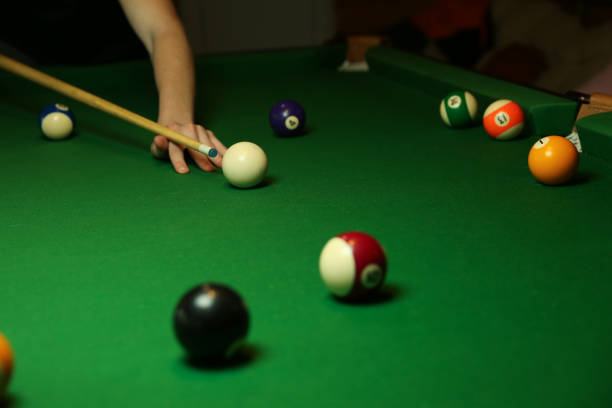istock pool balls and billiard cue on green billiard table. 1289515150