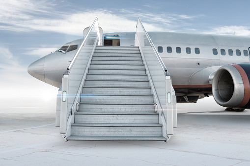 Avión de pasajeros con una escalera de embarque en el delantal del aeropuerto aislado en fondo brillante con el cielo photo