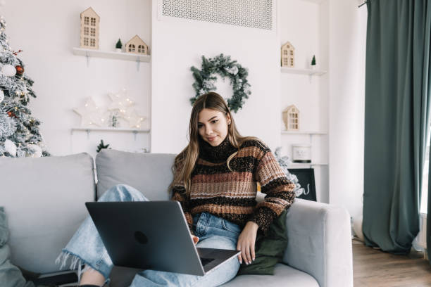 istock Young caucasian woman using laptop computer in holidays at home on the sofa. 1289524779