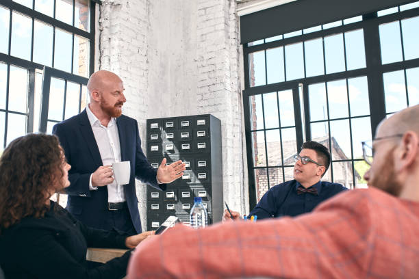 istock Beautiful business people are using gadgets, talking and smiling during the conference in office 1289525411