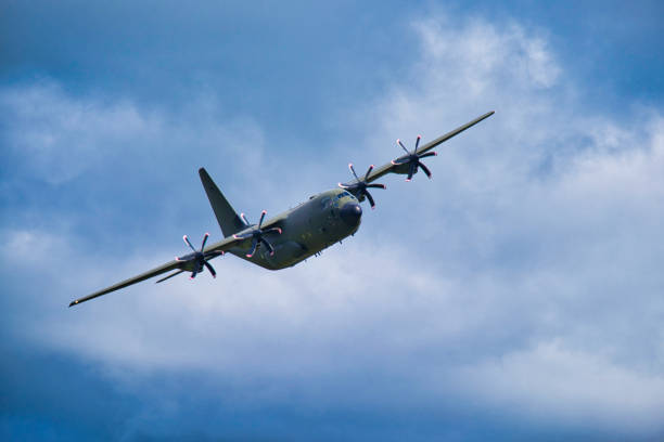 RAF Lockheed C130 Hercules against blue grey sky, Wales, Britain Royal Air Force transport aircraft banking raf stock pictures, royalty-free photos & images
