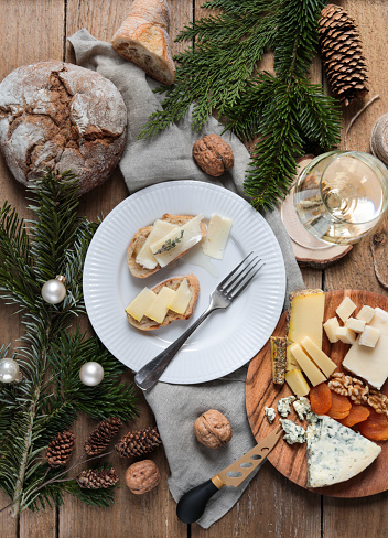 rustic Christmas Cheese Board flatlay with White Wine and bread on wood