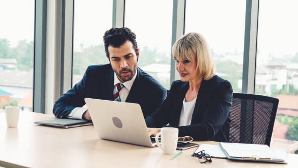 istock Two business people talk project strategy at office 1289532835