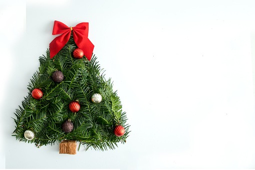 Creative Handmade Christmas tree on a white background, with a red bow and decorative balls. Flat lay