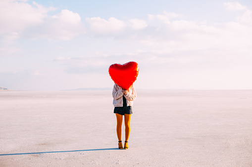 Woman Holding a Red Heart Balloon