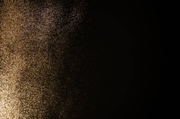 Luxury background concept made of golden shiny glitters dust gradient on dark surface, modern and elegant concept, flat lay, top view