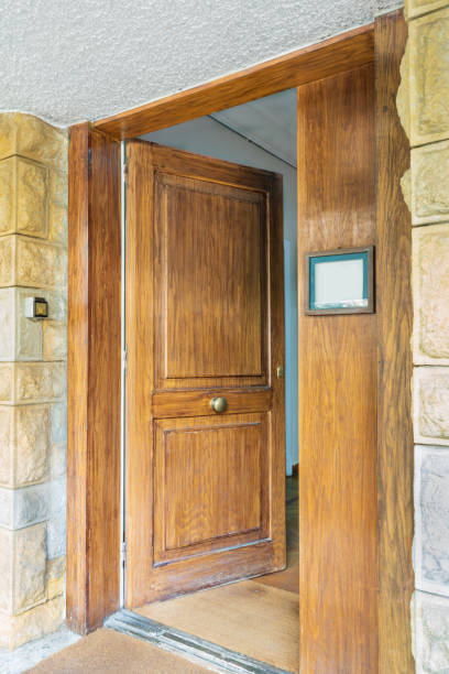 istock Opened front wooden door at yellow and gray decorative uneven stone bricks wall 1289535910