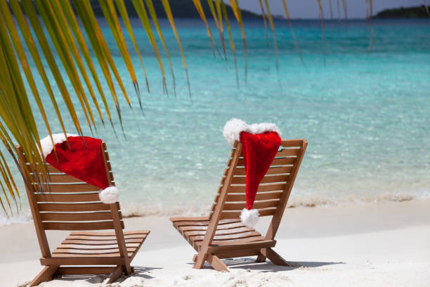 istock Beach Chairs with Christmas hats on a tropical beach 1289536686