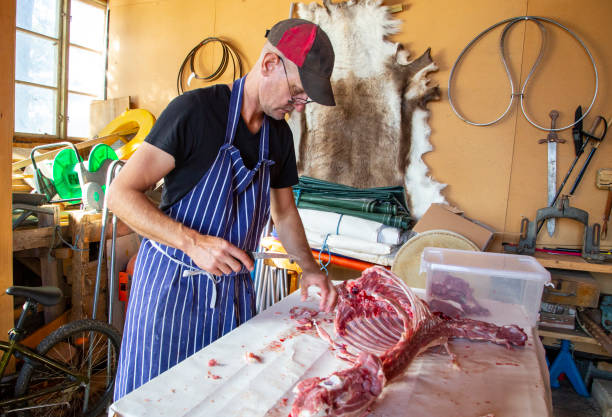 istock Butcher cutting up lamb carcasse in old shipyard building. 1289537822
