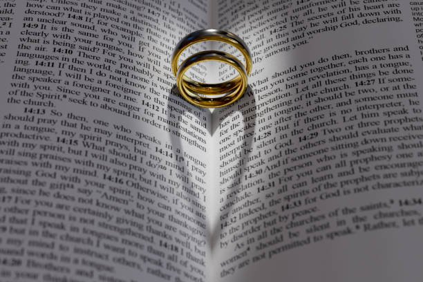 istock Two wedding rings on a bible 1289543000