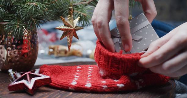 istock Human hands are packing Christmas gifts into the sock 1289544140