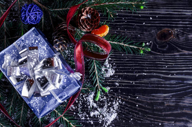 istock Blue gift box, decorations and fir branches on a dark background Christmas and new year theme.New year greeting card 1289547653