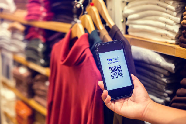 istock Selective focus to payment QR code tag on smartphone with blurry many clothes in the store to accepted generate digital pay without money. 1289548473