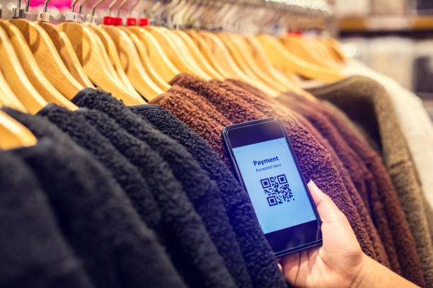 istock Selective focus to payment QR code tag on smartphone with blurry many clothes in the store to accepted generate digital pay without money. 1289548493