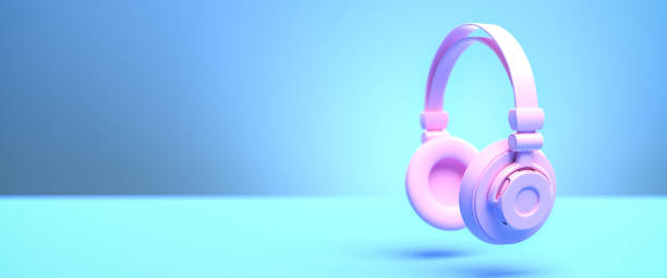 istock Music concept: A pink headphone against a blue background with shadow. Web banner size with copy space - selective focus on foreground 1289549256