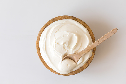 Greek yogurt in a wooden bowl. Healthy breakfast.Homemade Fatty Dairy product, sour cream, mayonnaise.