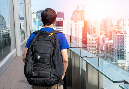 Traveller or backpacker travel with backpack on skyscrapper in urban city