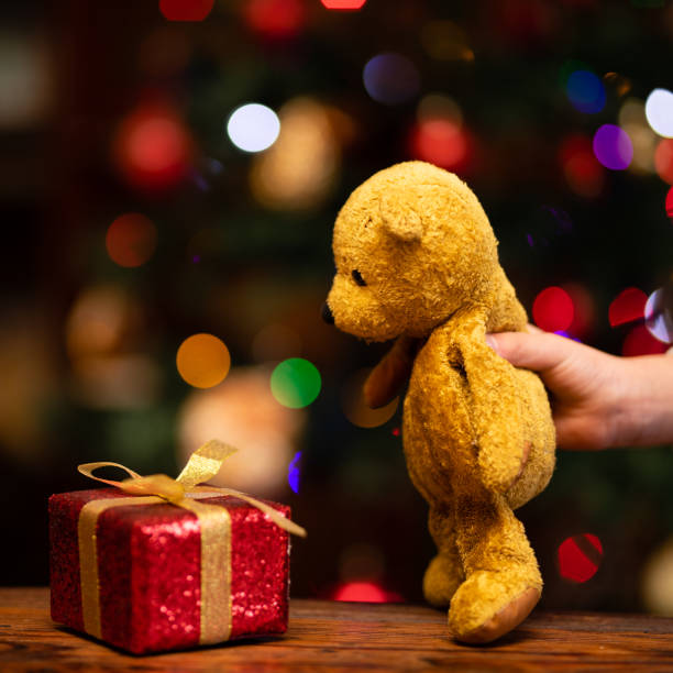 istock Children's hands playing with Christmas gift and teddy bear 1289551168