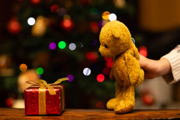 istock Children's hands playing with Christmas gift and teddy bear 1289551176