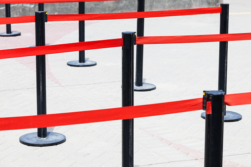 fence with red ribbons on the street