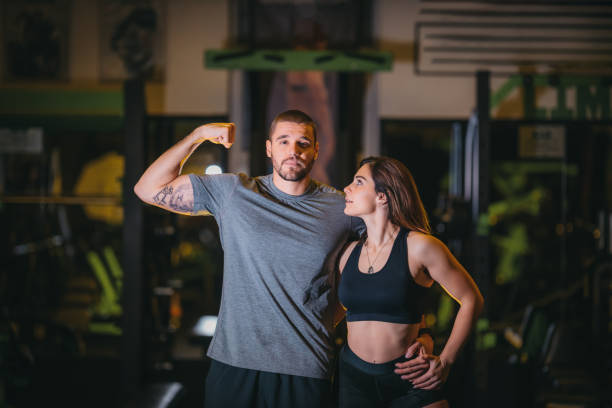 istock Cheerful athletic couple having fun while exercising in a gym 1289555435