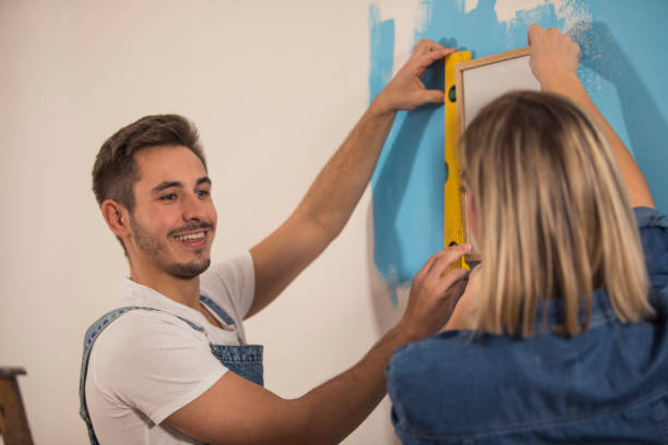 istock Putting up picture frame and seeing if it is even 1289565361