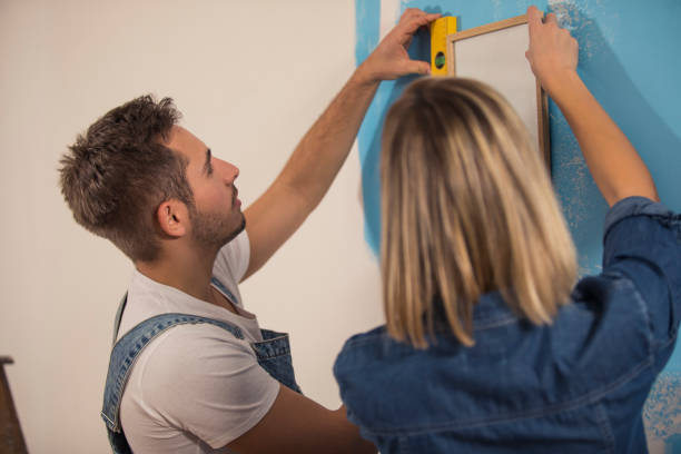 istock Young couple seeing if the picture frame is even 1289565730