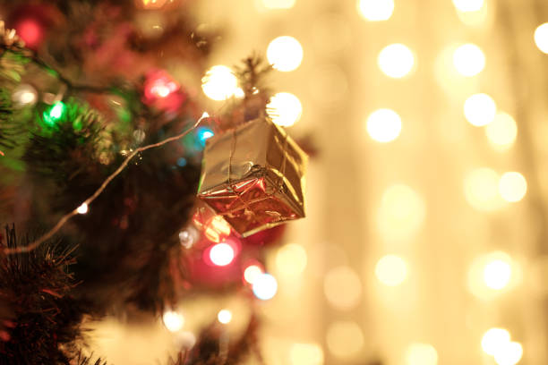 istock Decoration for Christmas tree in form of tiny giftbox wrapped into golden paper 1289566939