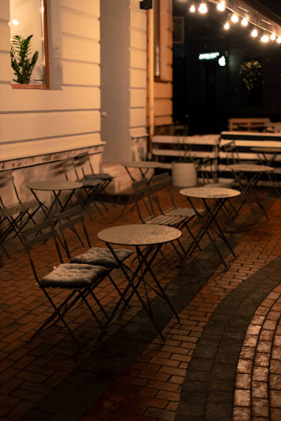 istock patio cafe table and chairs in evening rainy time, no people on empty street 1289568149