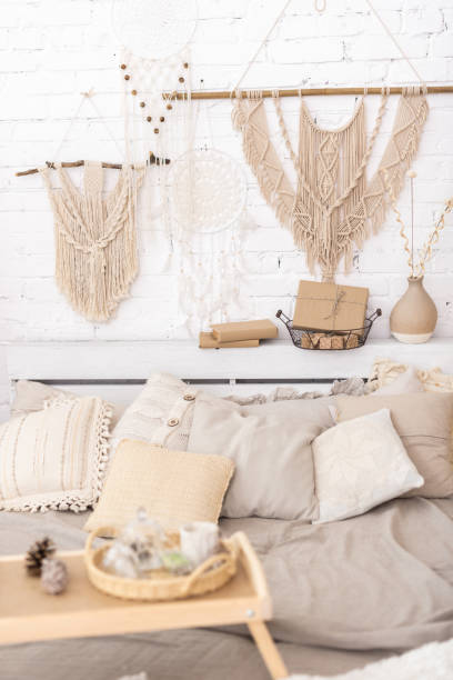 istock Stylish bedroom interior in beige shades with wall macrame 1289570923