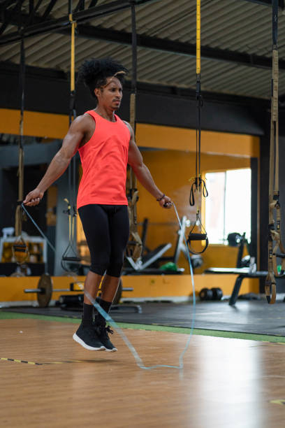 istock Black athlete jumping rope wearing sportswear inside gym 1289574248