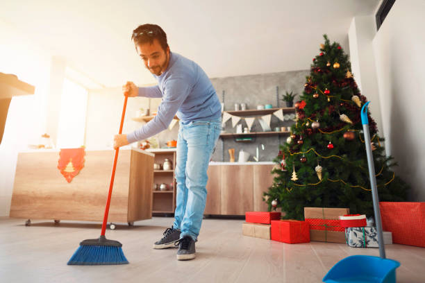 mid adult man barriendo piso con una escoba - dust dusting cleaning broom fotografías e imágenes de stock