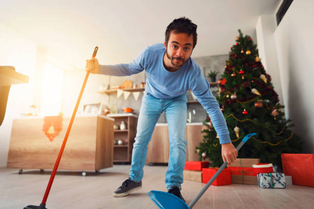 istock Mid adult man sweeping floor with a broom and a dustpan 1289576015