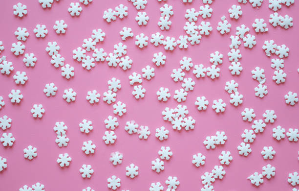 istock pink christmas background with snowflakes 1289576033