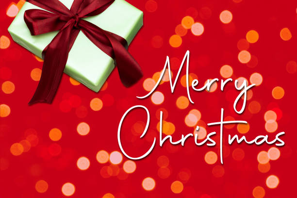 istock gift box with merry christmas on bokeh red background 1289576062