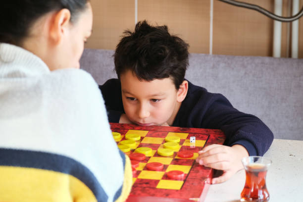 istock Child playing checkers game with his mother 1289576251