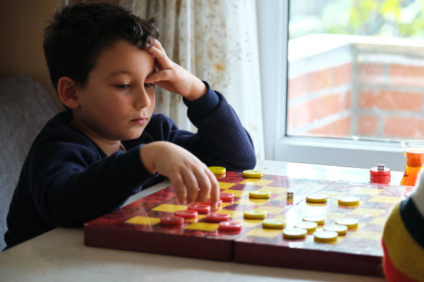 istock Child playing checkers game with his mother 1289576293