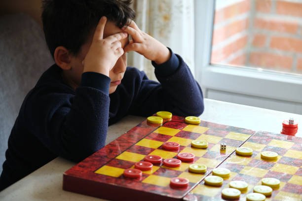istock Child playing checkers game with his mother 1289576307