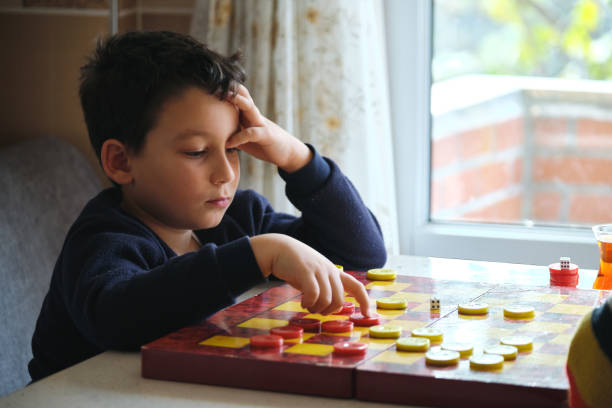 istock Child playing checkers game with his mother 1289576314