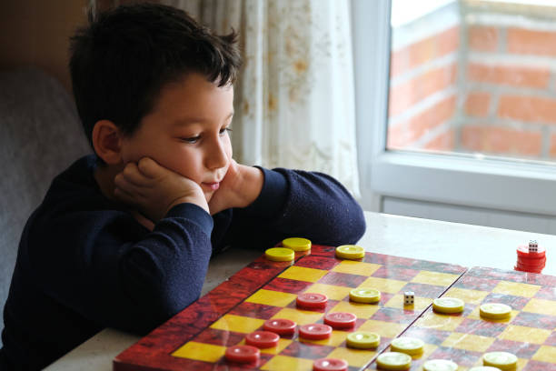 istock Child playing checkers game with his mother 1289576826