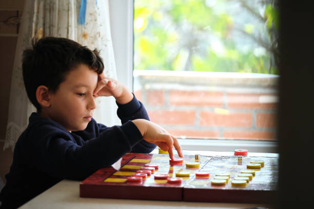 istock Child playing checkers game with his mother 1289576845