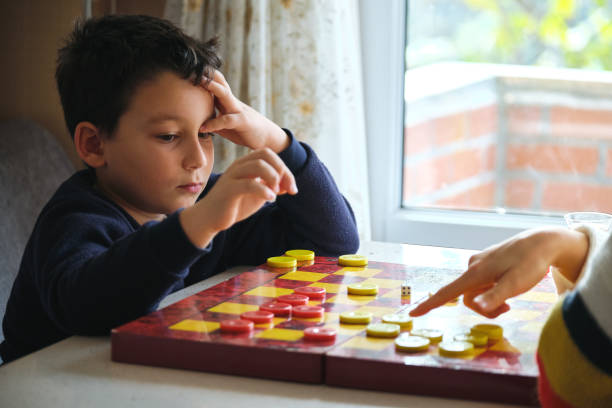 istock Child playing checkers game with his mother 1289576853