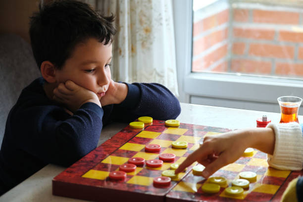 istock Child playing checkers game with his mother 1289576870