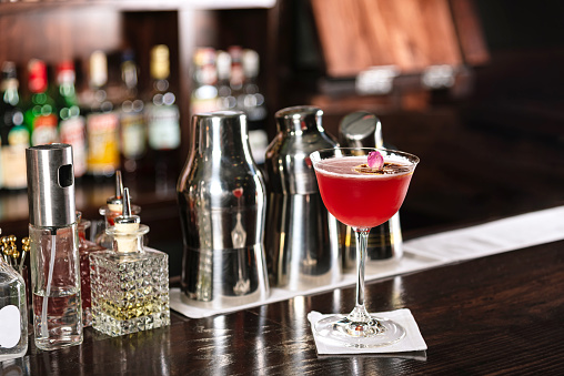 Mai tai cocktail on bar counter garnished with rose on bar counter ready to drink.